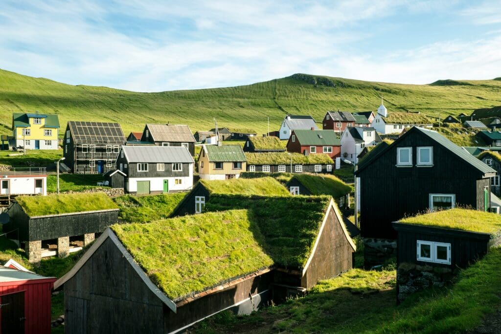 Dorf aus Erdhäusern mit Grasdächern in nordeuropäischer Landschaft