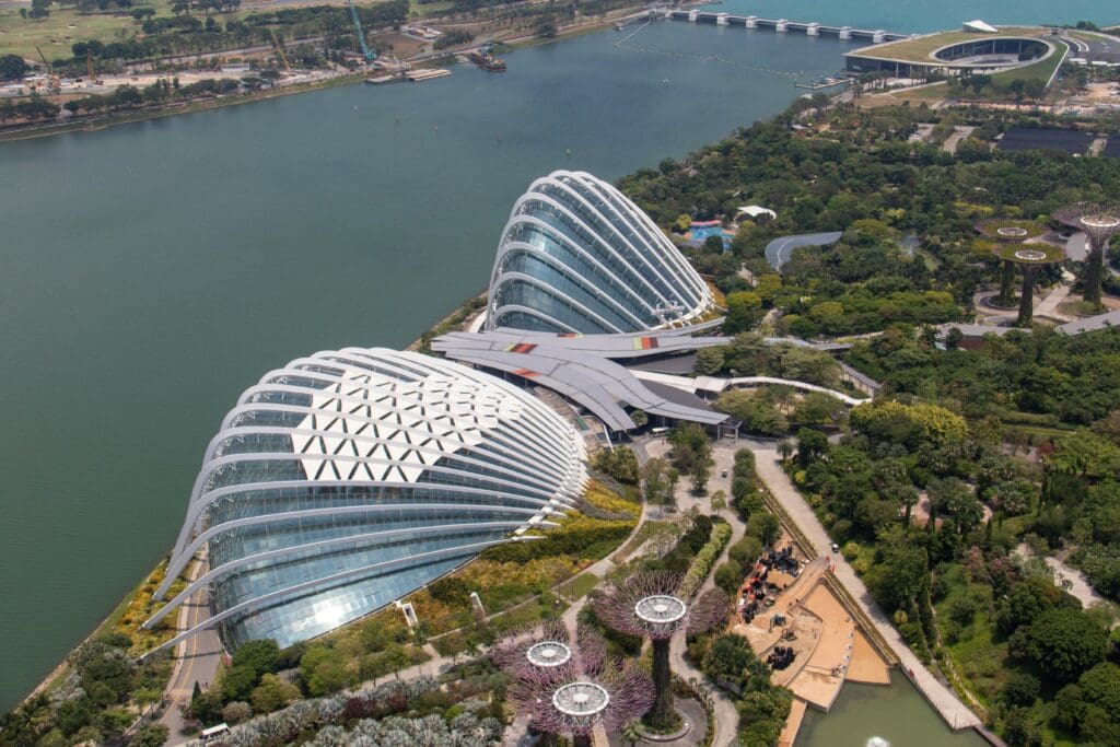 Luftaufnahme der dynamisch geformten Glashallen von Gardens by the Bay, wo man durch Nebelwälder wandeln kann