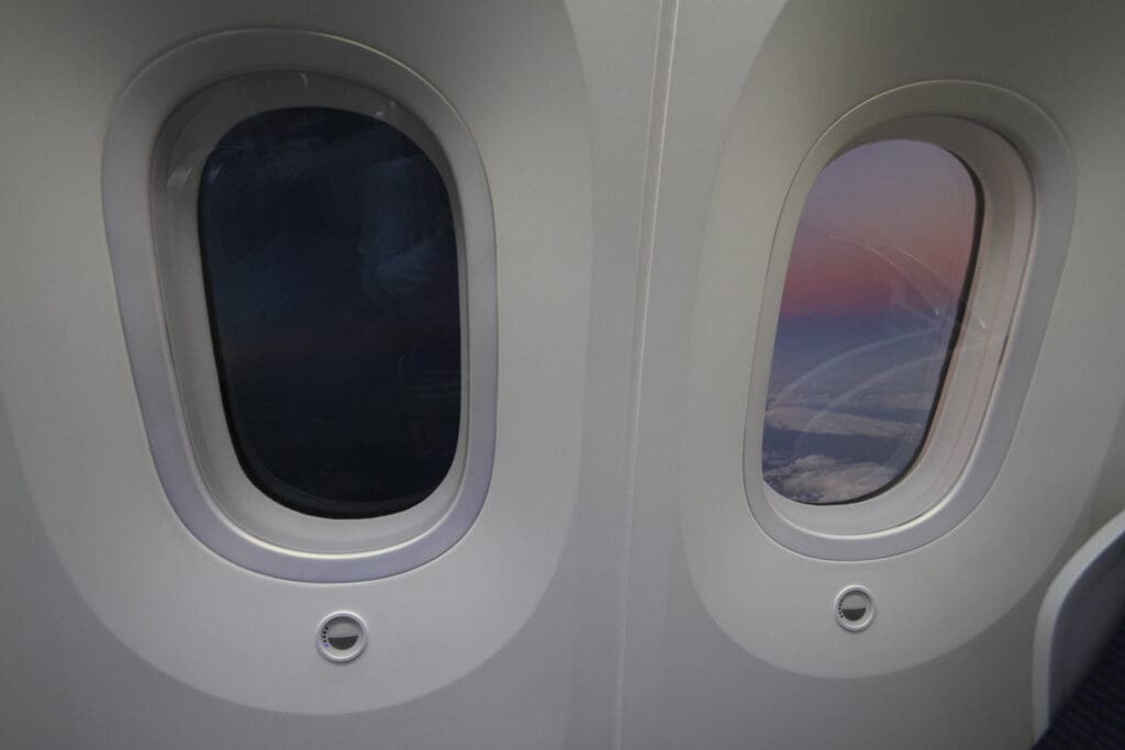 Demonstration von Smart Glass Scheiben in einem Flugzeug: das linke Kabinenfenster ist getönt, während das rechte Fenster klar ist (nicht getönt)
