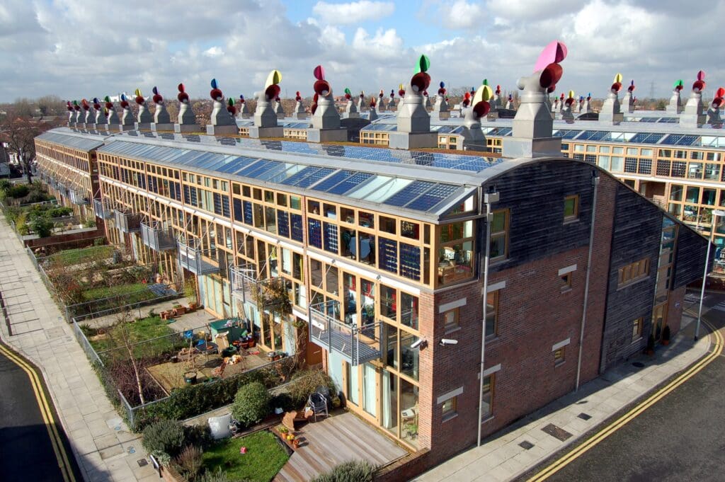 Beddington, Großbritannien: Reihen von Niedrigenergie-Wohnhäusern aus dem Jahr 2002; zur Sonne ausgerichtete Fenster, Photovoltaik-Paneele auf dem geschwungenen Dach und ausgefallene bunte Hauben zur Belüftung