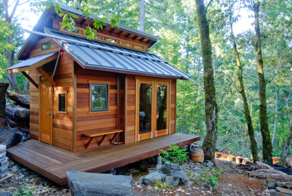 Tiny House aus hellem Holz im Wald