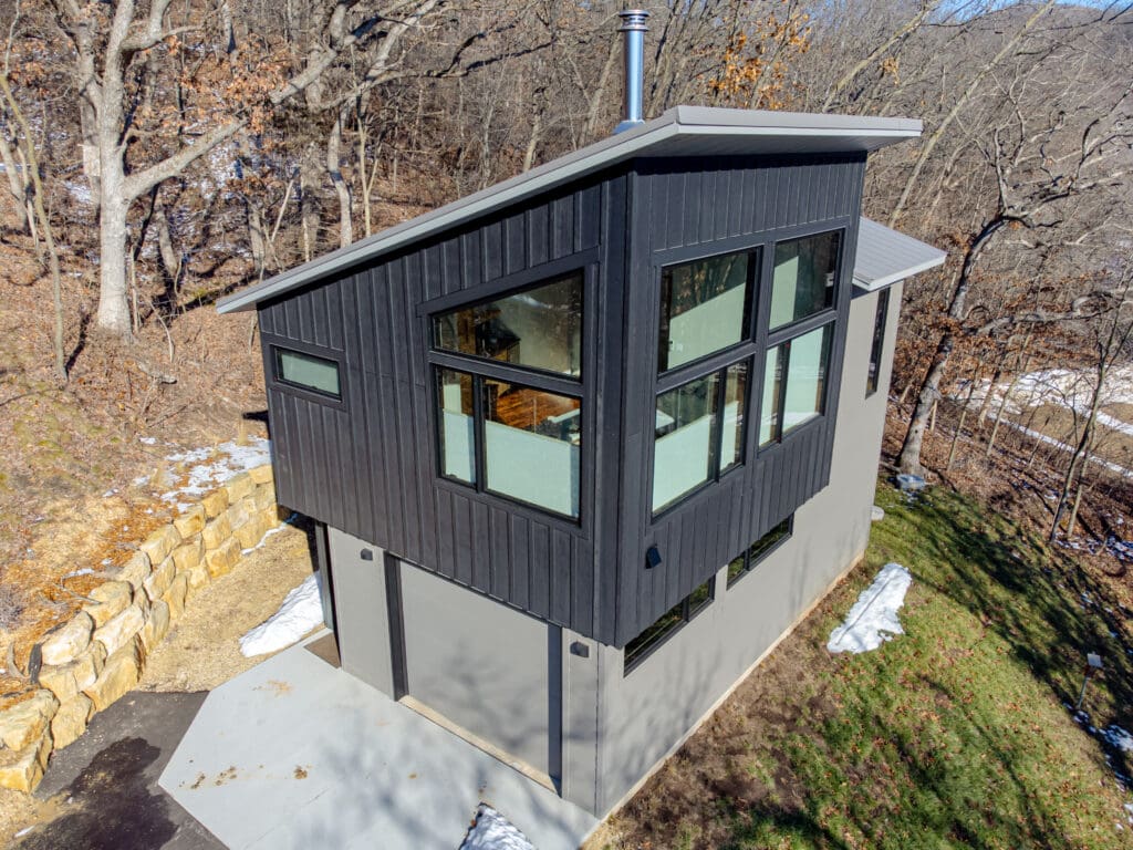 Ein zweistöckiges Tiny House mit Garage im Erdgeschoss