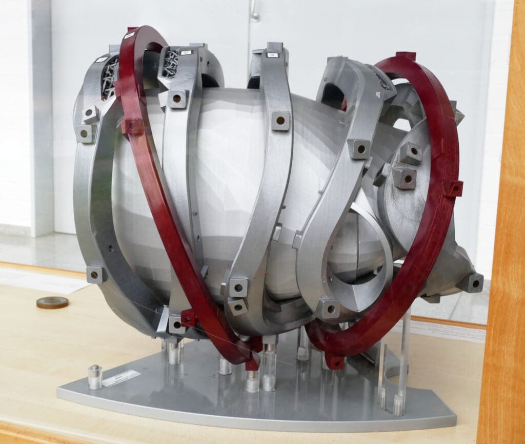 Exhibition segment of a "doughnut" shaped Stellarator fusion reactor; the bespoke, intricated coils can clearly be seen