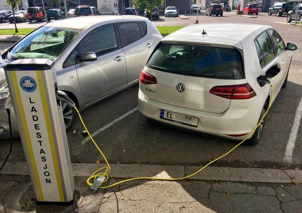 A  silver Nissan and a white Volkswagen e-golf are being charged
