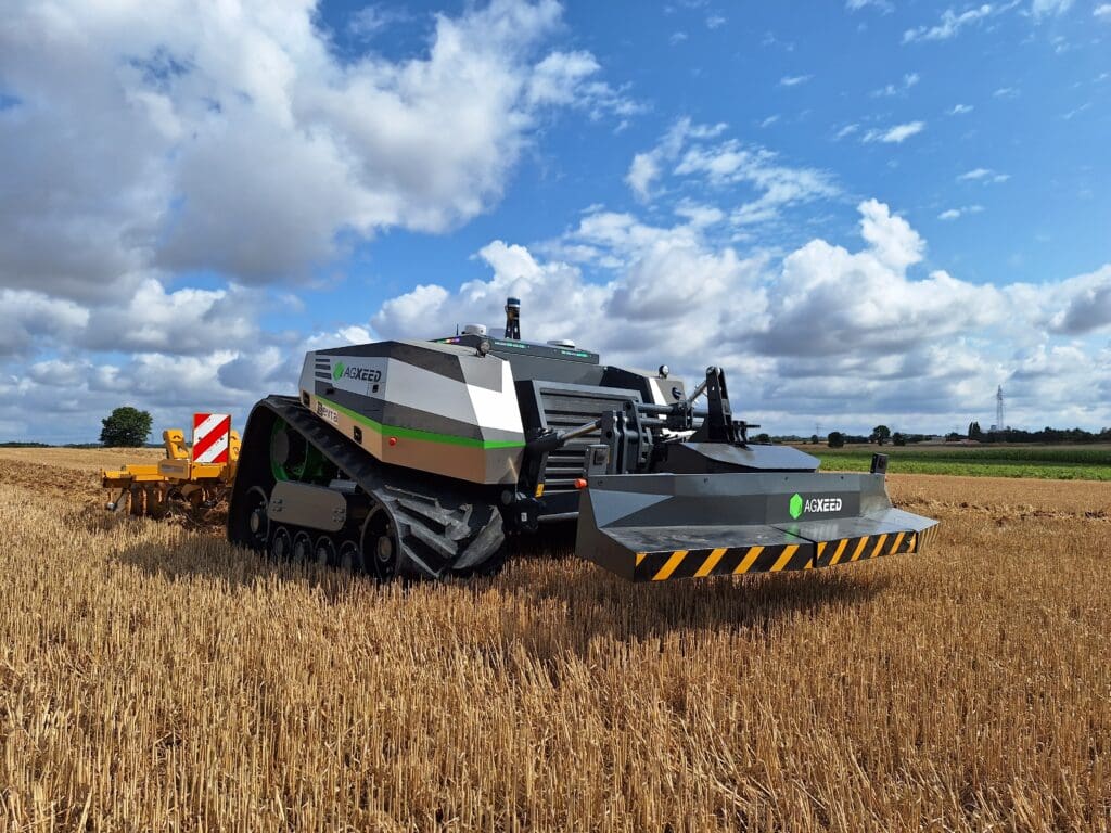 Autonomous AgXeed tractor operates on a harvested crop field; its design is relatively flat as it does not require a cockpit.
