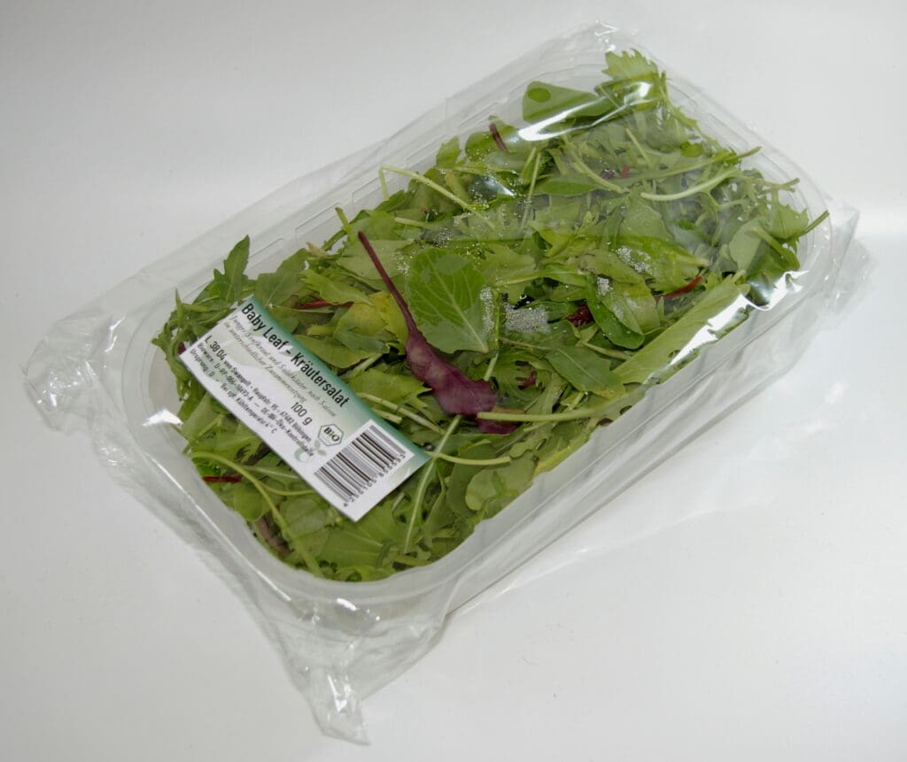 Transparent blister wrap around a green salad container