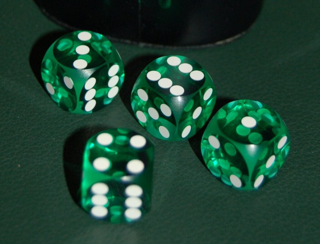 Four transparent, neon green biopolymer dice on a dark green surface